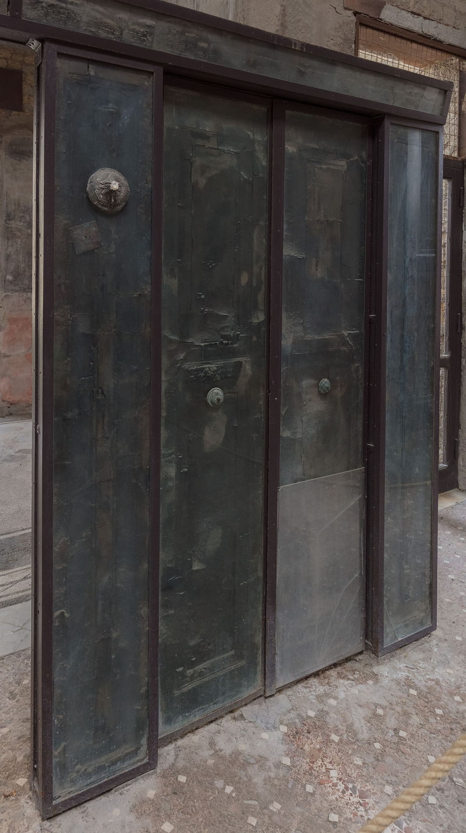 il tramezzo di legno carbonizzato della Casa del Tramezzo di Legno, dietro il vetro