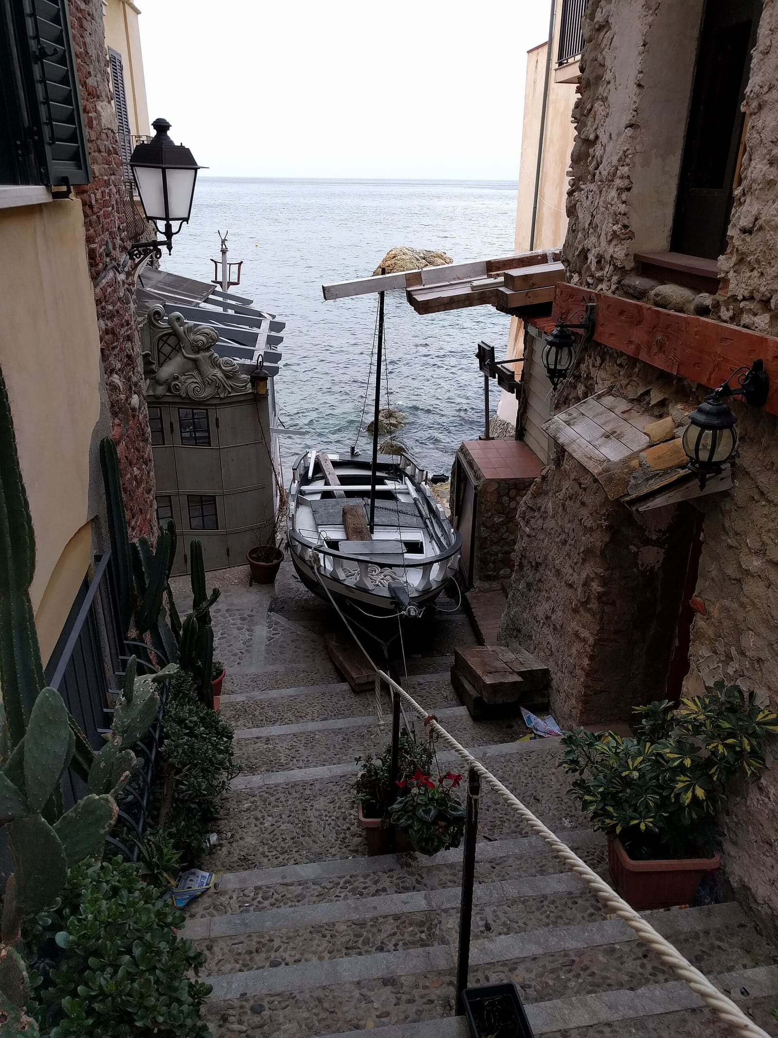 a stepped alley of Chianalea going down to the sea, with a boat pulled up