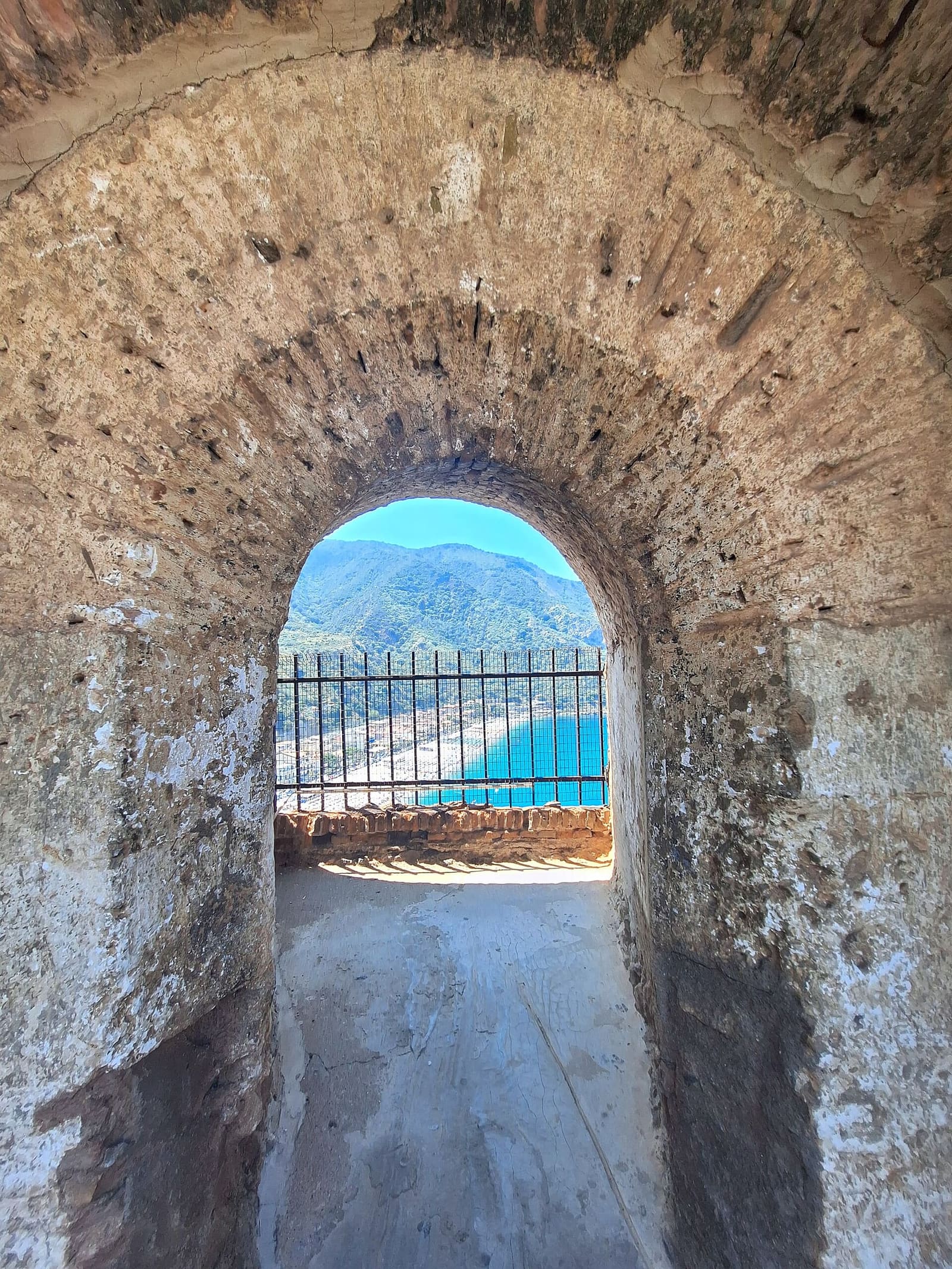 a castle window with its grille, and below it the beach of Marina Grande