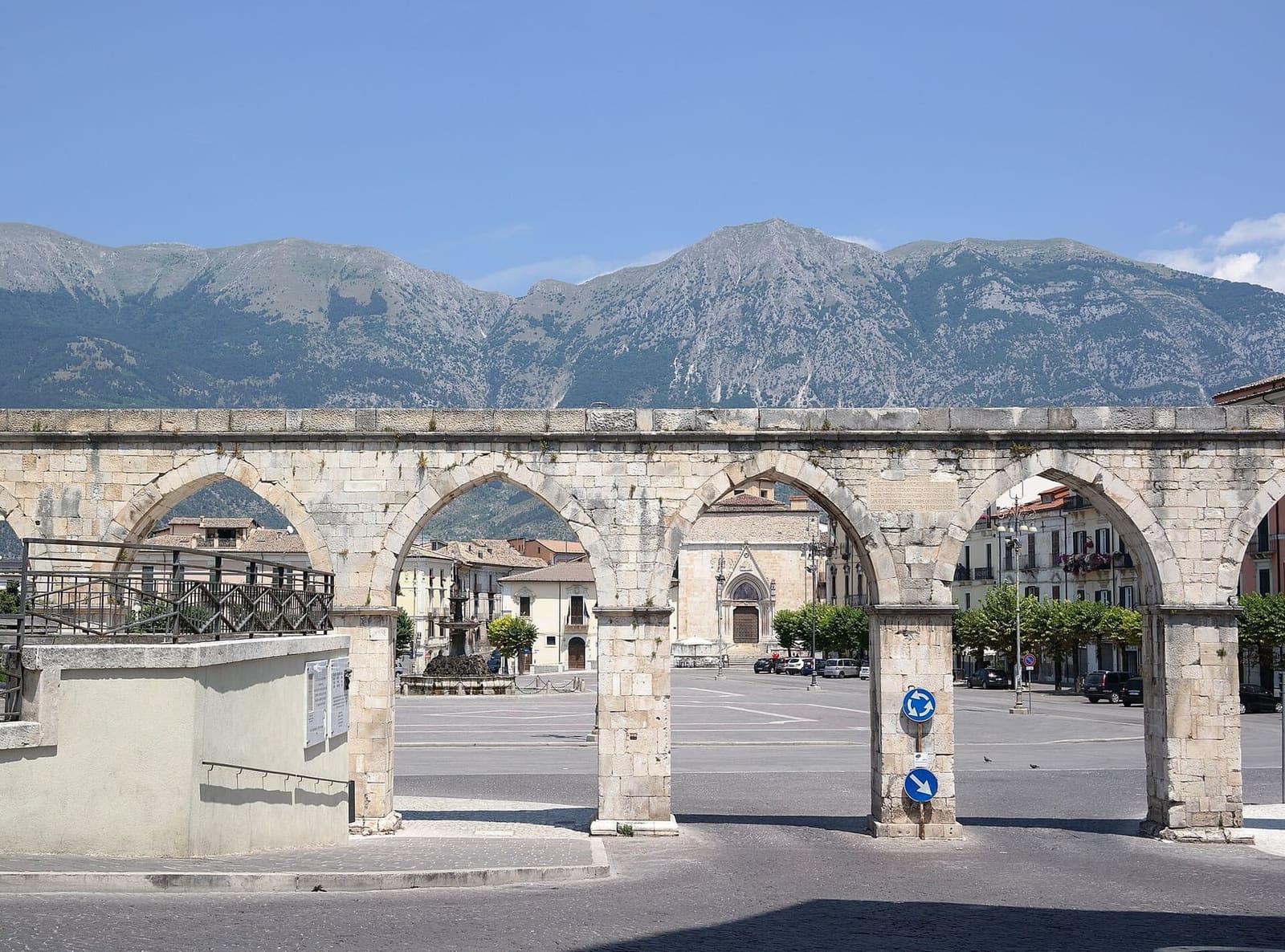 the arches of the Swabian aqueduct on piazza Garibaldi, with the Morrone in the background