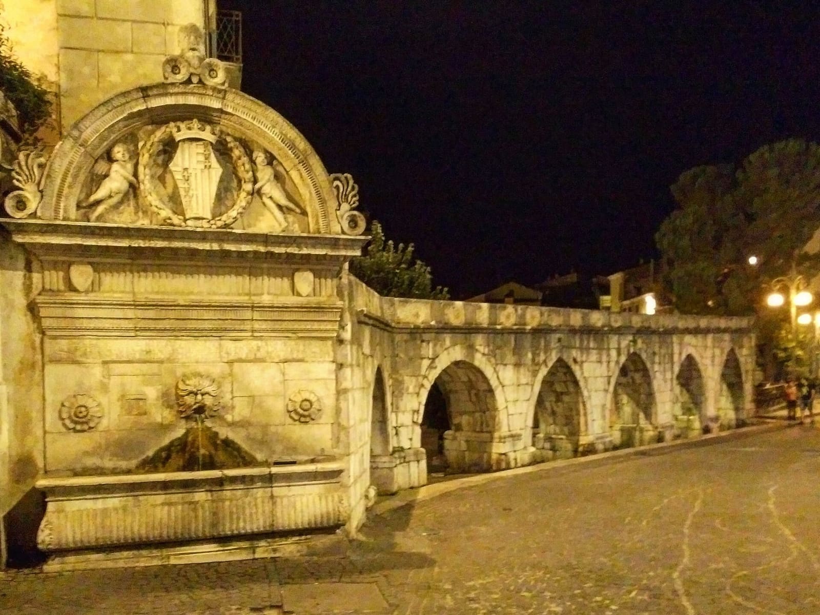the Fontana del Vecchio, where the Swabian aqueduct ends, lit up in the evening