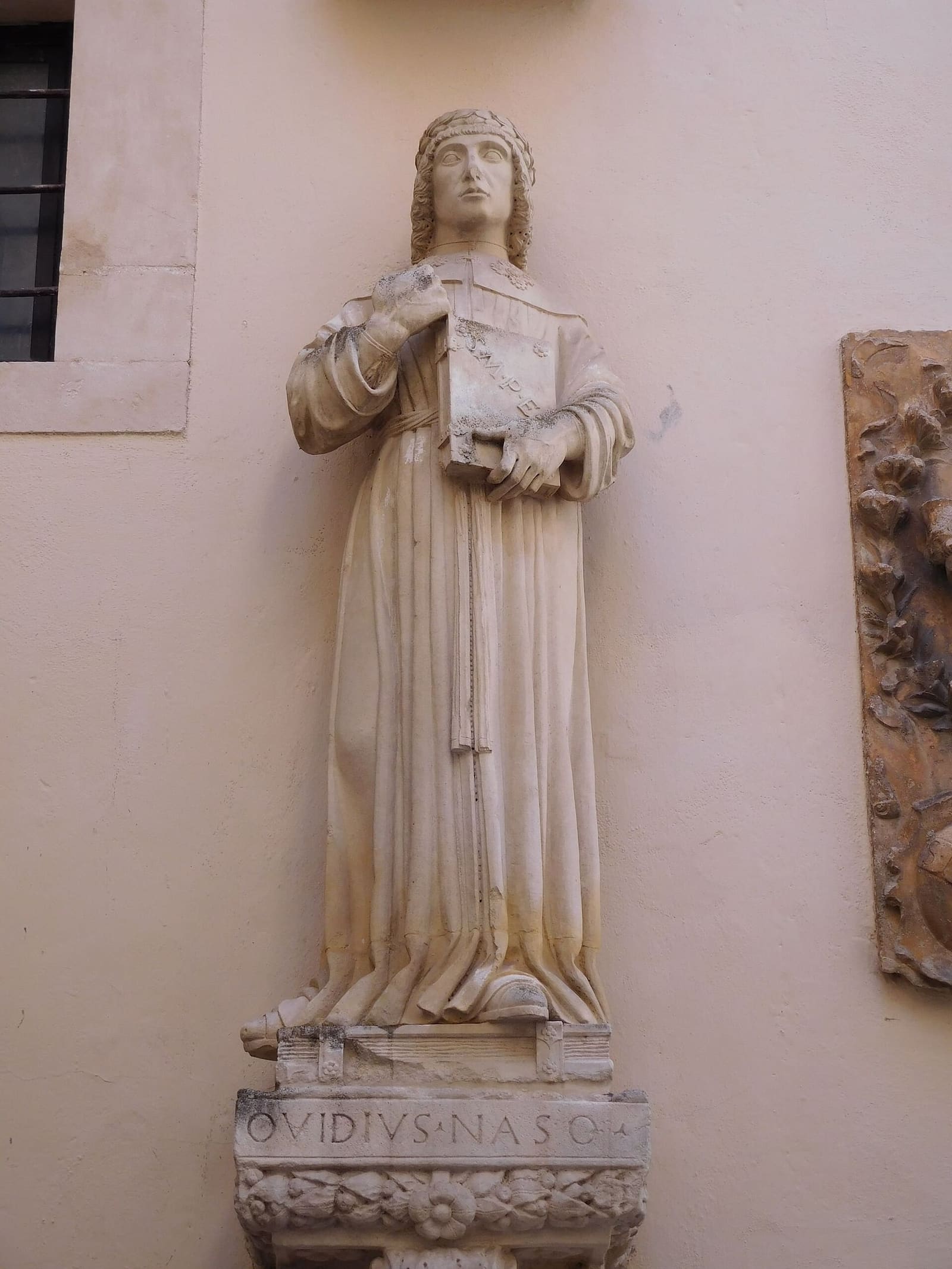Ovid dressed as a medieval scholar with a book in his hand, the statue in the palazzo of the Annunziata