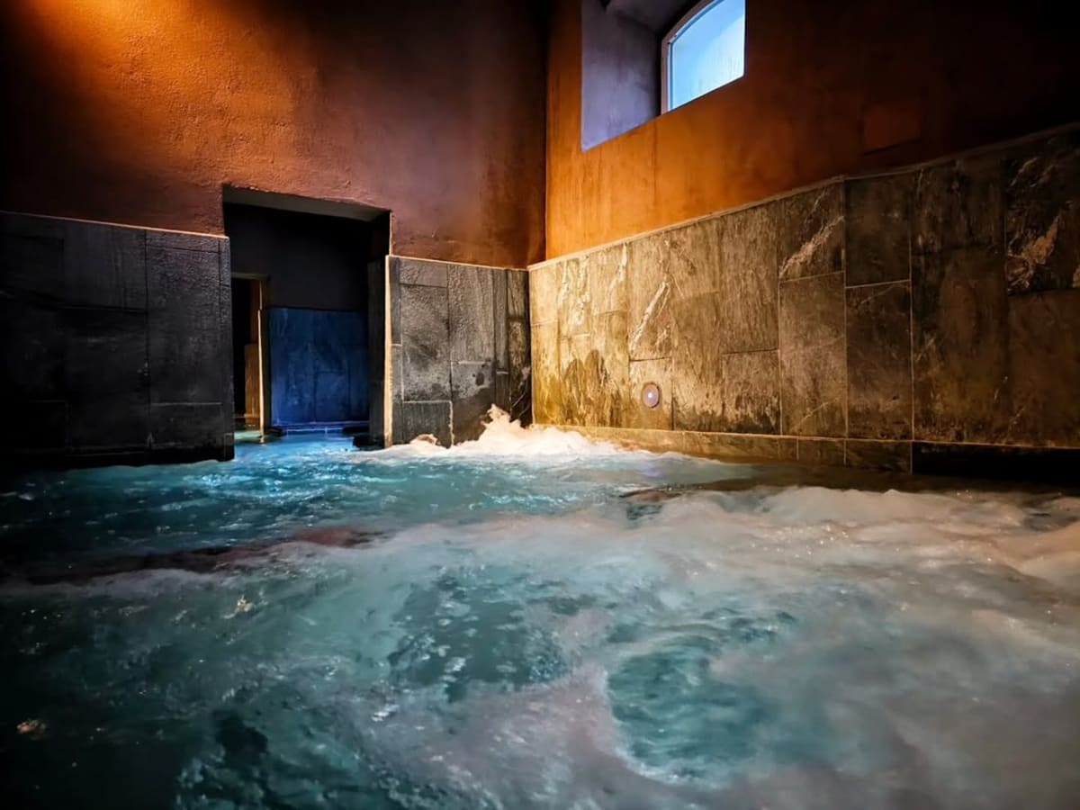 una delle vasche interne, pareti di pietra e acqua mossa dagli idromassaggi
