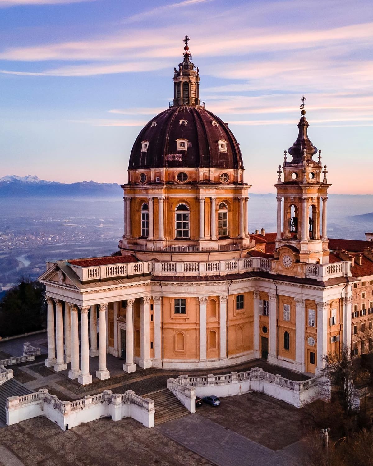 la basilica di Superga in cima alla collina, con la pianura e le Alpi dietro, al tramonto