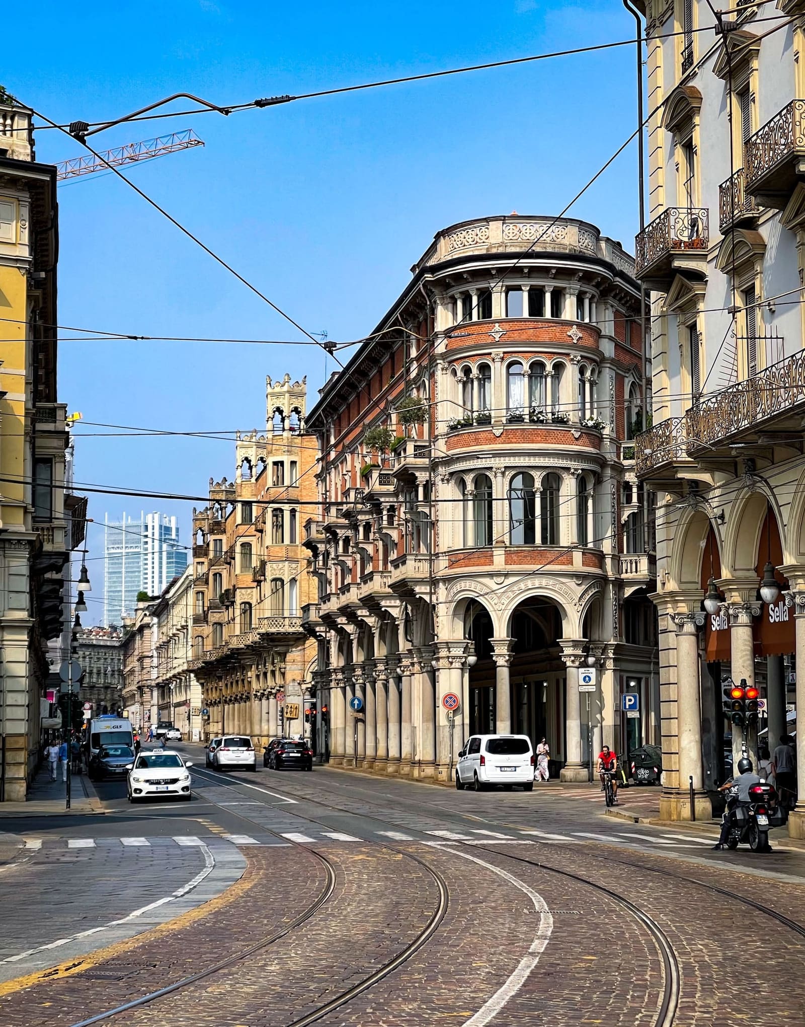 via Pietro Micca, i palazzi eclettici di fine Ottocento sopra i portici e le rotaie del tram, con Palazzo Bellia sull'angolo e il grattacielo Intesa Sanpaolo in fondo