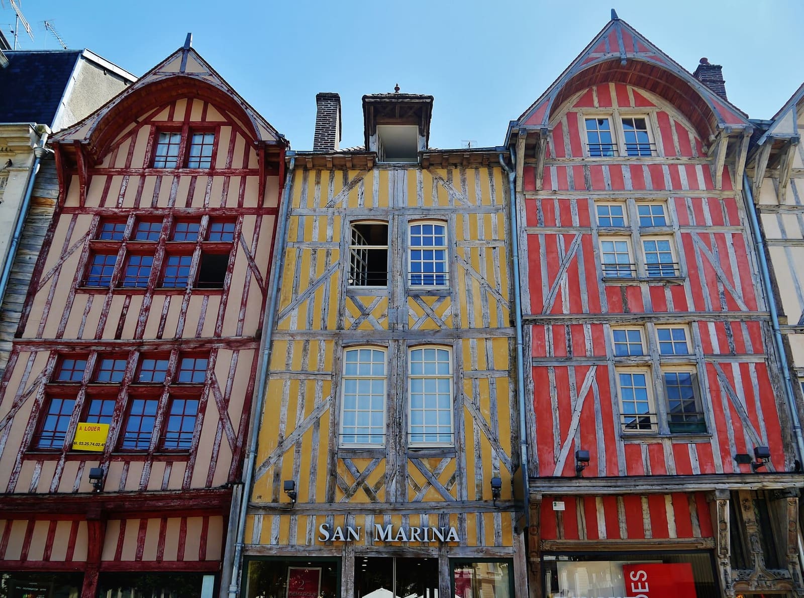 le case a graticcio dipinte di rosso, giallo e rosa in rue Émile-Zola, nel centro di Troyes