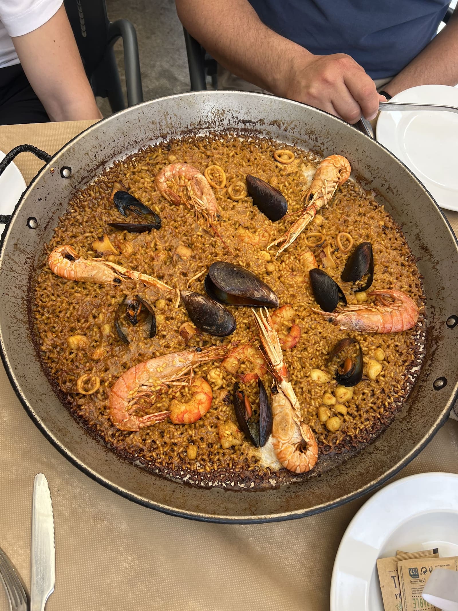 la paella di mare appena portata in tavola, con gamberi, scampi e cozze sul riso