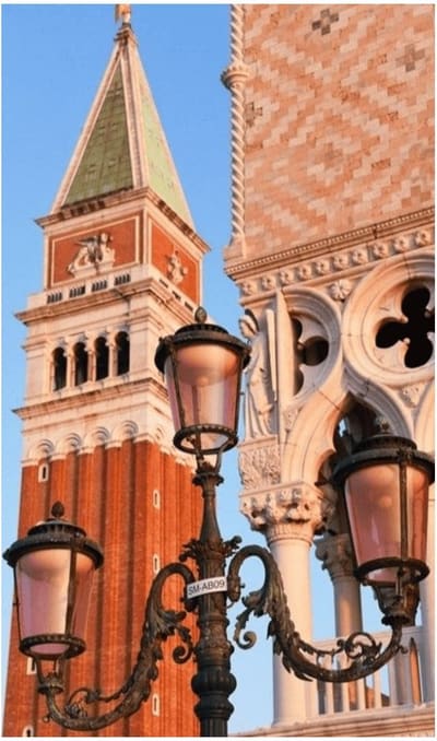 il Campanile di San Marco e la facciata gotica del Palazzo Ducale dietro un lampione a tre bracci