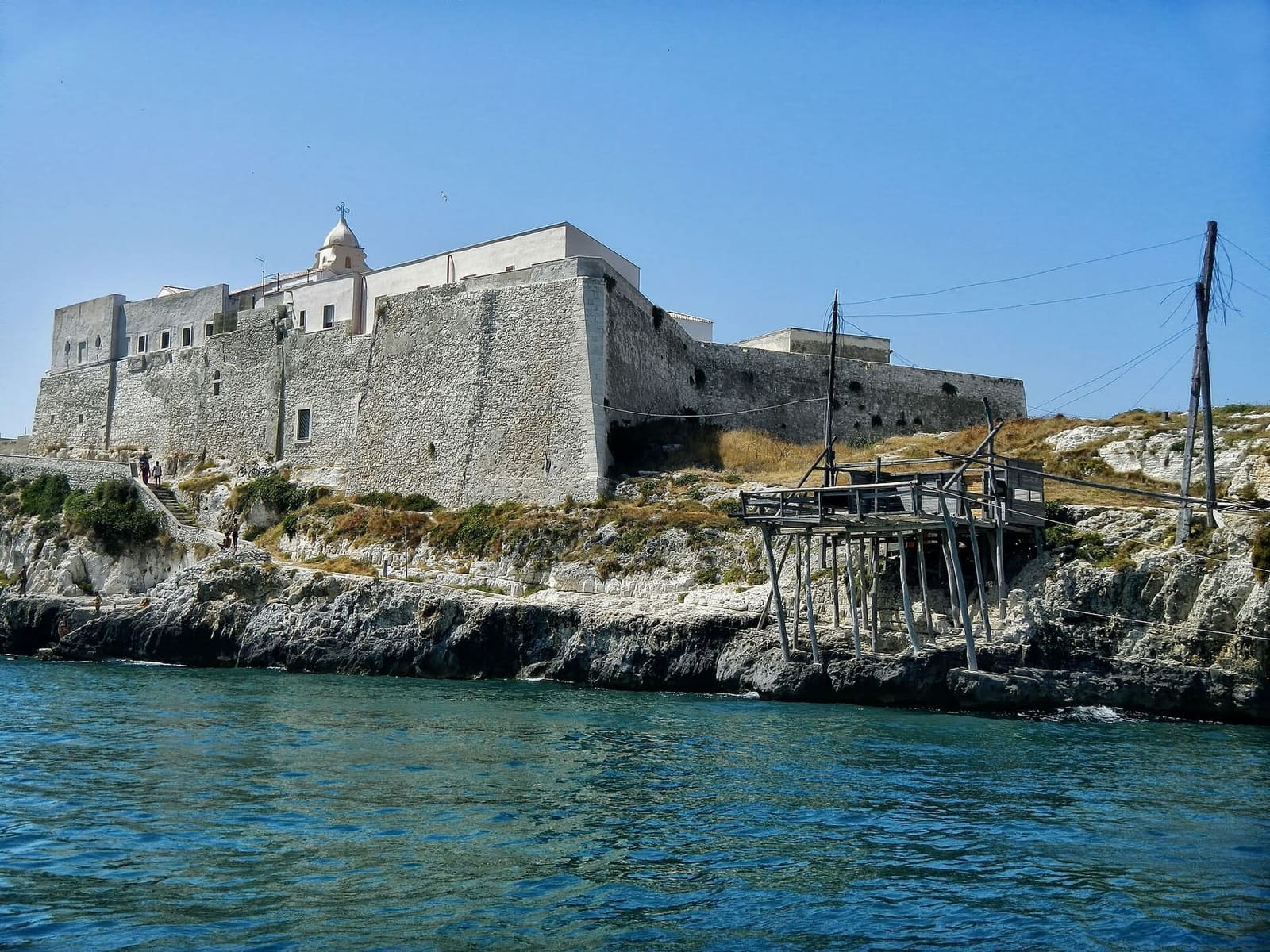 das Castello Svevo auf dem Felsen, vom Meer aus gesehen, mit einem Trabucco darunter