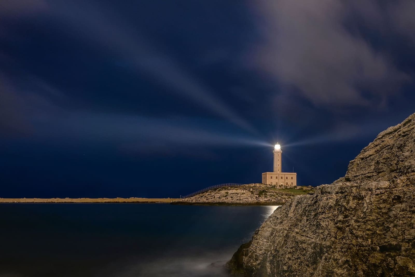 der Leuchtturm von Sant'Eufemia bei Nacht, mit seinen Strahlen