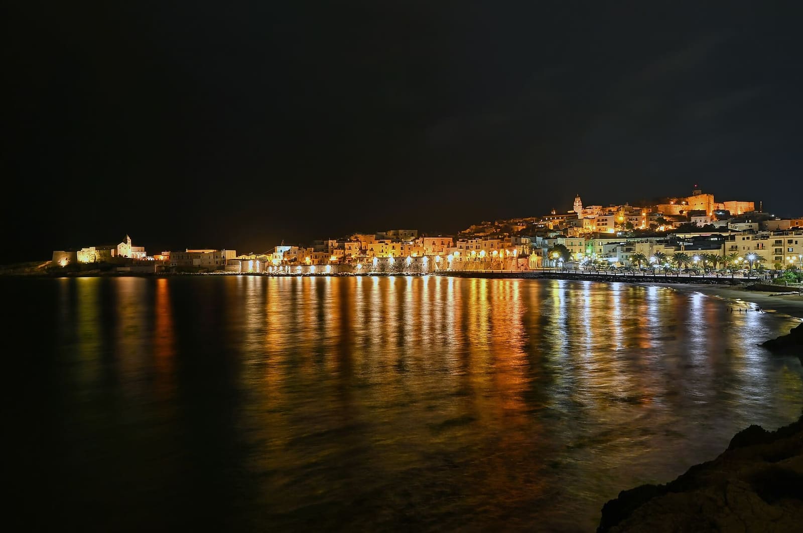 Vieste bei Nacht vom Strand aus gesehen, mit den Lichtern auf dem Wasser